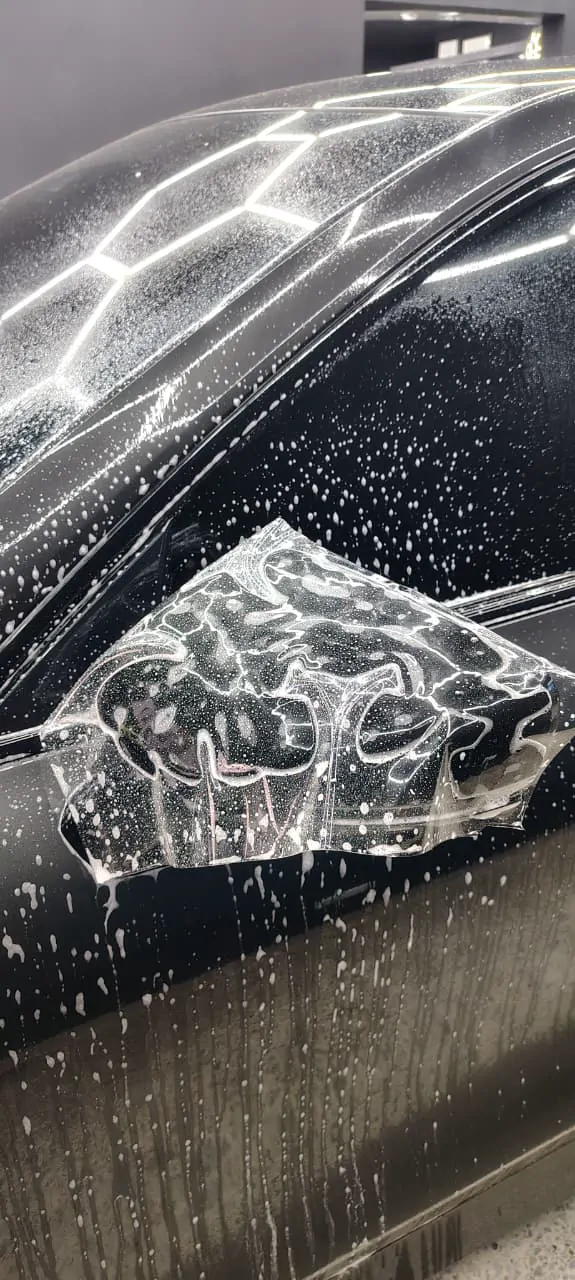 Instalación de PPF en el espejo de un Tesla en Cali